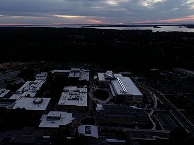 Aerial view of campus at dusk with sunset and water views in background